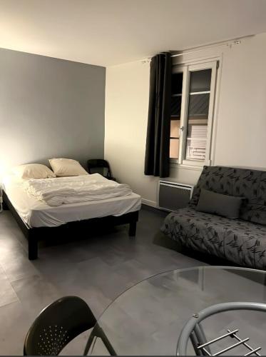 un salon avec un lit et un canapé dans l'établissement Le Carrel, à Rouen