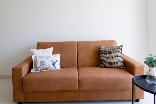 a brown couch with pillows on it in a living room at Suite Pomezia in Pomezia