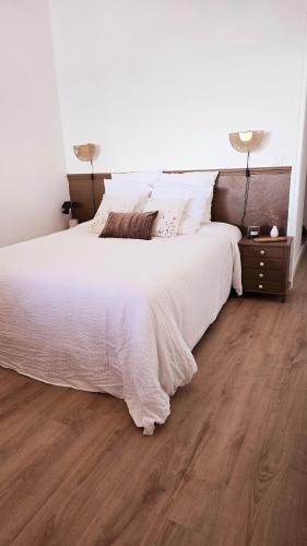 - une chambre avec un lit blanc et du parquet dans l'établissement Appartement vue sur le golf de Porto, à Porto Ota