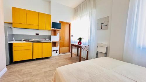 a kitchen with yellow cabinets and a table in a room at Residence & Suites in Bellaria-Igea Marina
