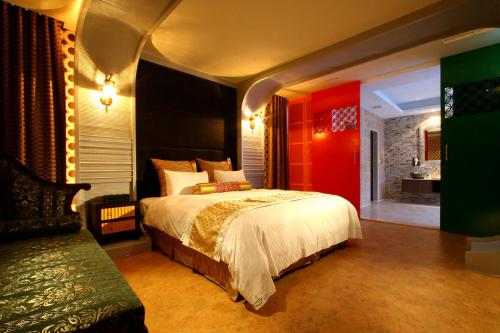 1 dormitorio con cama grande y pared roja en Melody Motel en Keelung