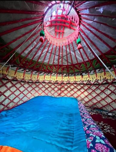 a room with a tent with a blue bed in it at Anarbek's Yurt Camp in Kol-Suu