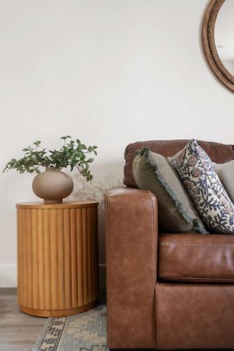 a brown leather couch with a plant on a table at Down Town Condo with gym pool BBQ jacuzzi in San Diego