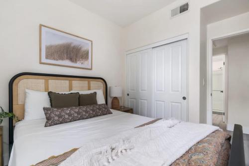 a bedroom with a large white bed and a door at Down Town Condo with gym pool BBQ jacuzzi in San Diego