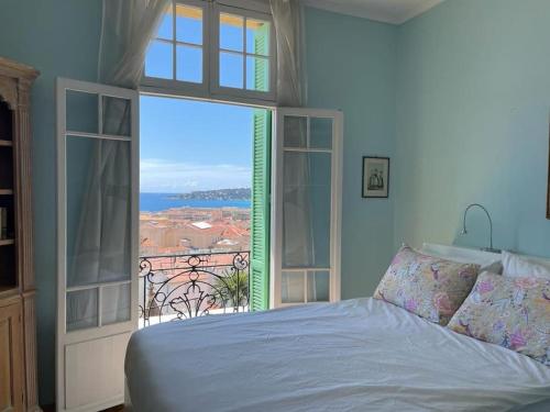 une chambre avec un lit et une grande fenêtre dans l'établissement villawoho Spacious terraces, panoramic seaview in quiet area, à Menton