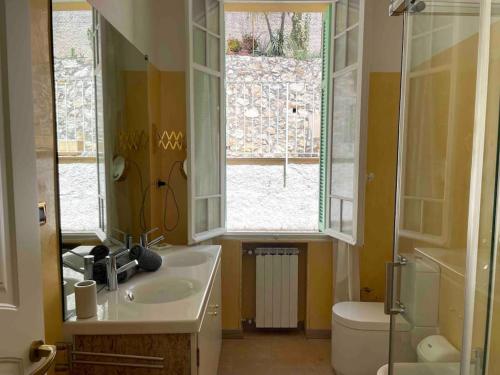une salle de bain avec un lavabo et des toilettes et une fenêtre dans l'établissement villawoho Spacious terraces, panoramic seaview in quiet area, à Menton