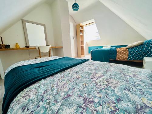 une chambre avec un grand lit avec une couette bleue dans l'établissement Maison de vacances Bretagne, à Tréveneuc