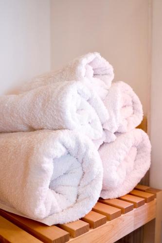 a stack of white towels sitting on a wooden shelf at "Lo Studiolo" in Nardò