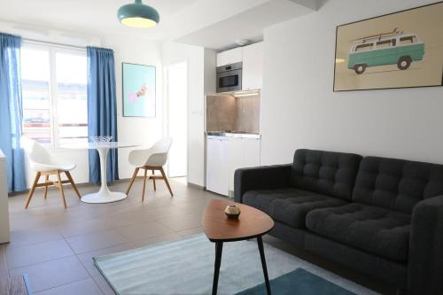 un salon avec un canapé et une table dans l'établissement Escapade Urbaine - Studio Lumineux proche gare, à Lyon