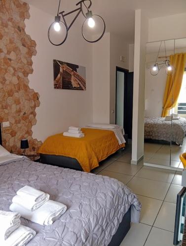 a bedroom with two beds and a stone wall at Megaride Santa Lucia in Naples
