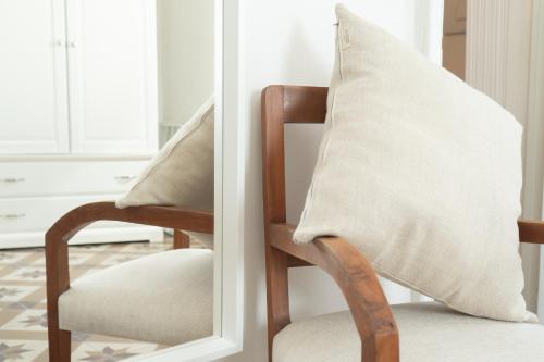a chair with a pillow on it next to a mirror at "Lo Studiolo" in Nardò