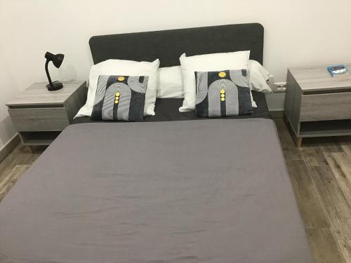 ein Schlafzimmer mit einem großen Bett und Kissen in der Unterkunft Une maison entière de 4-5 pers avec piscine in Le Pizou