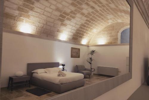 a bedroom with a bed in a room with a brick wall at Residence Masseria Santa Lucia in Matera