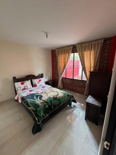 a bedroom with a bed and a large window at Cabañas San Luis in Moniquirá