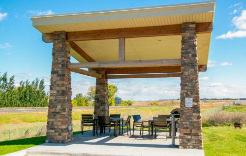 a patio with tables and chairs under a roof at My Place Hotel-Jamestown, ND in Jamestown