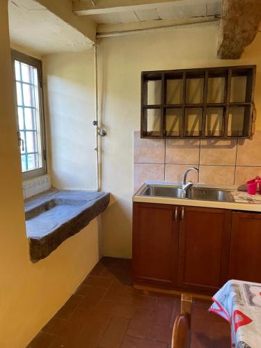 a small kitchen with a sink and a window at SO MAGIC - La casa nel bosco in San Godenzo
