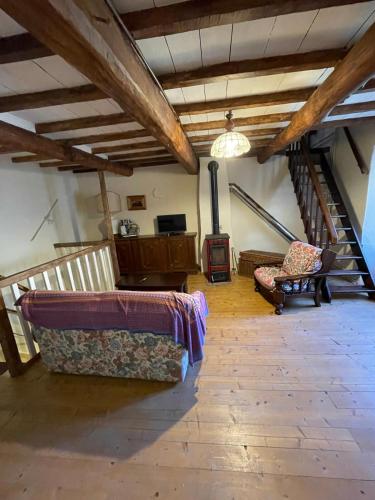 a living room with two couches and a staircase at SO MAGIC - La casa nel bosco in San Godenzo