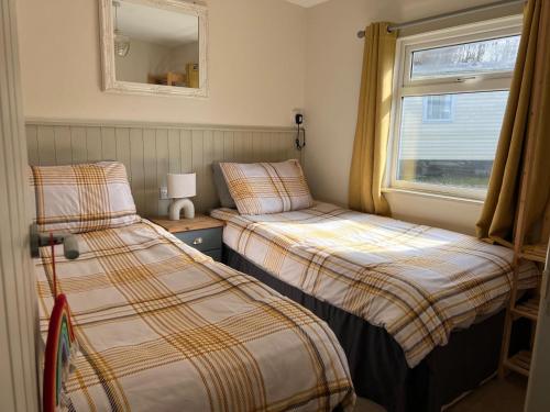 Ένα ή περισσότερα κρεβάτια σε δωμάτιο στο Woodlands Hare Chalet, Bideford Bay Holiday Park
