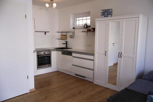 a kitchen with white cabinets and a counter top at Seeappartements Stadtflucht in Mörbisch am See