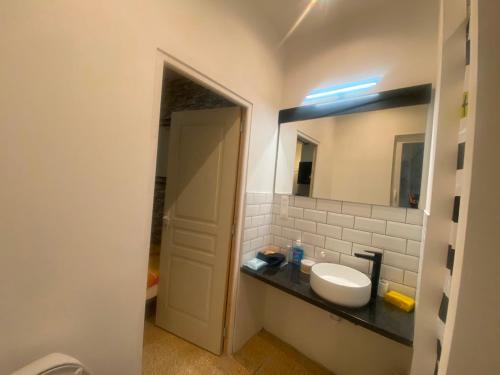 une salle de bain avec un lavabo et un miroir dans l'établissement Nationale, à Nîmes