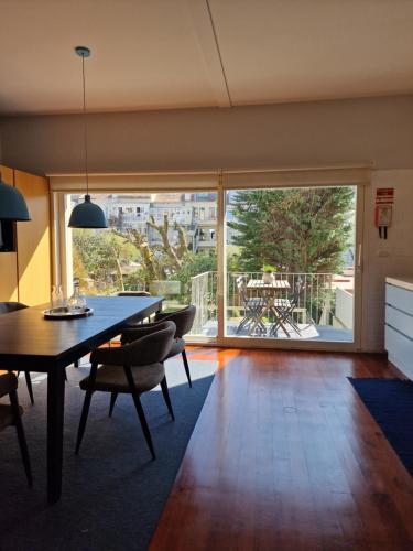 a dining room with a table and chairs and a large window at Lima Junior Residences in Porto