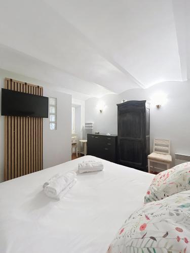 une chambre avec un lit blanc avec deux serviettes dessus dans l'établissement Les Fleurs, à Cannes