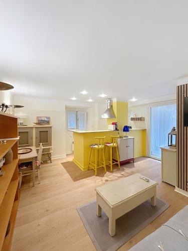 un salon avec une cuisine aux murs jaunes dans l'établissement Les Fleurs, à Cannes
