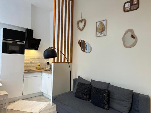 a living room with a couch and a kitchen at Appart Cosy avec Terrasse - Ideal Couple - Zen - LeRelaisdOdile41 in Valenciennes