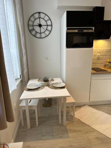 une cuisine avec une table et une horloge au mur dans l'établissement Appart Cosy avec Terrasse - Ideal Couple - Zen - LeRelaisdOdile41, à Valenciennes