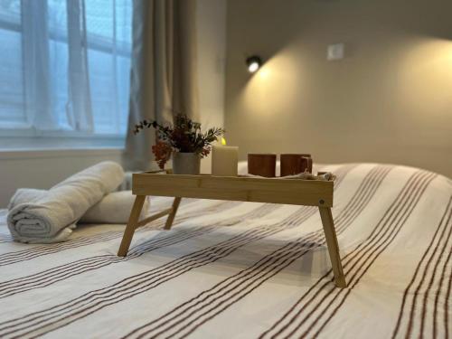 a wooden table sitting on top of a bed at Appart Cosy avec Terrasse - Ideal Couple - Zen - LeRelaisdOdile41 in Valenciennes