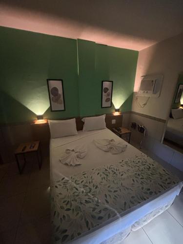 a bedroom with a bed with a green wall at Villa Mar Boa Viagem in Recife