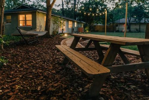 a wooden picnic table in front of a house at Boho 4BR Oasis w Mini Golf & Games in Gainesville