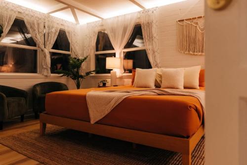 a bedroom with a bed in a room with windows at Boho 4BR Oasis w Mini Golf & Games in Gainesville