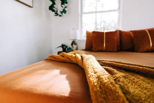 a blanket laying on top of a bed at Boho 4BR Oasis w Mini Golf & Games in Gainesville