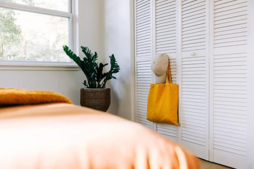 a bedroom with a bed and a yellow bag at Boho 4BR Oasis w Mini Golf & Games in Gainesville