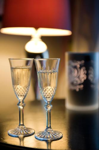 two wine glasses sitting on a table with a lamp at Torre Di Vico Residenza D'Epoca in Viterbo