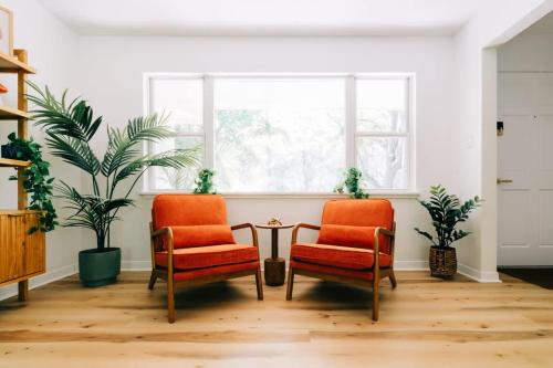 two chairs and a table in a room with a window at Boho 4BR Oasis w Mini Golf & Games in Gainesville