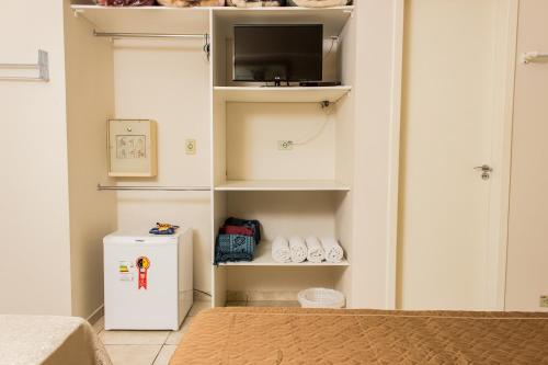 a room with a small refrigerator and a tv at Pousada Cataratas in Foz do Iguaçu