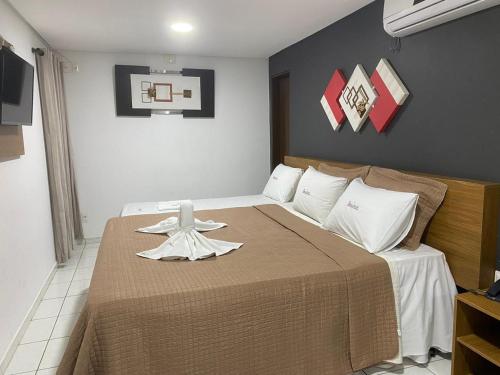 a bedroom with a bed with a brown blanket at Hotel Rota do Sertão in Serra Talhada