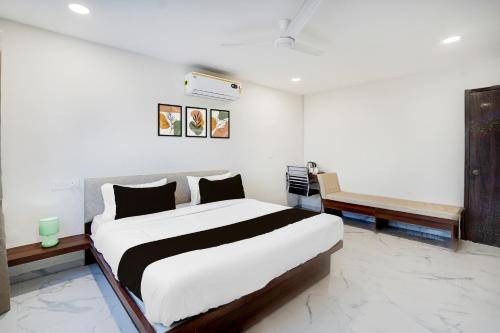 DhantoliSuper Collection O Omkar Nagar Nagpur的一间卧室配有一张大床和一张长凳