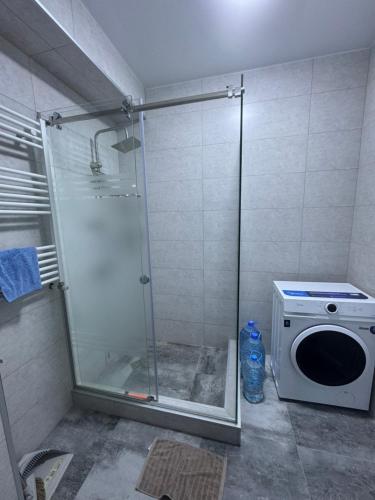 a shower stall with a washing machine in a bathroom at monolit residens 6C blok in Tbilisi City