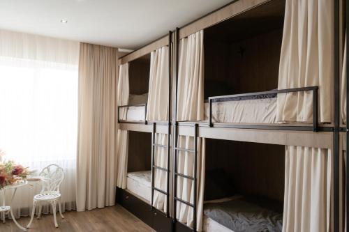 a room with bunk beds with a table and a window at Garden plaza in Neresnytsya