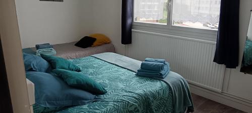 une chambre avec un lit avec des oreillers bleus dessus dans l'établissement le folkestone, à Boulogne-sur-Mer