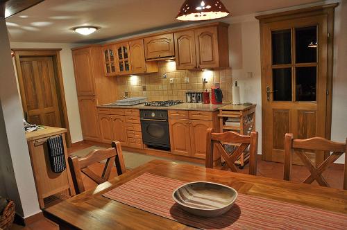 a kitchen with wooden cabinets and a wooden table at Apartment Rogla Lodge in Zreče