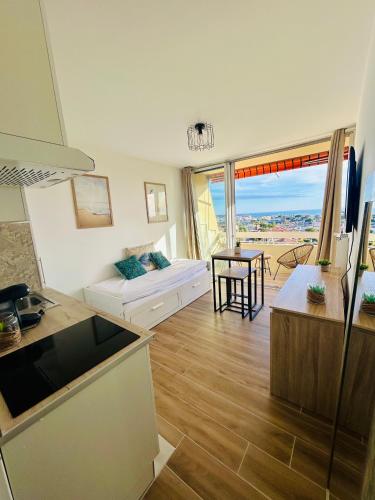 un salon avec un canapé et une table dans l'établissement Joli cozy studio vue mer, à Antibes