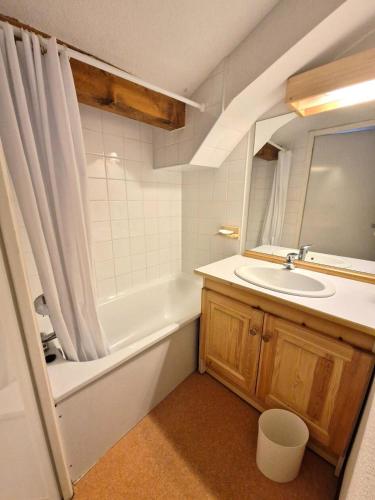une salle de bain avec un lavabo, une baignoire et un miroir dans l'établissement Les Chalets D'arrondaz - Grand appartement 10/12 personnes MAE-2893, à Modane