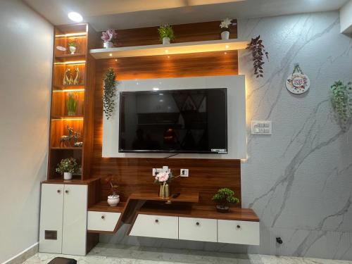 a living room with a television on a wall at Atlas Homes 1BHK HomeStays in Hyderabad