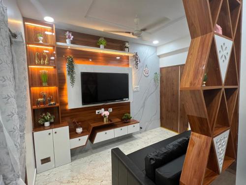 a living room with a television on a wall at Atlas Homes 1BHK HomeStays in Hyderabad