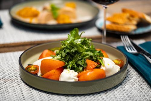 a bowl of food with carrots and greens on a table at Hilton Hotel Tahiti in Papeete