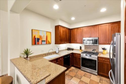 a kitchen with wooden cabinets and a counter top at Ground Floor 1BR Legacy Villa #A in La Quinta